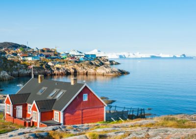 Bunte Häuser am Ufer des atlantischen Ozeans in Ilulissat, Westgrönland