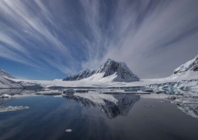 Berglandschaft im Schnee vor beeindruckender Wolkenkulisse